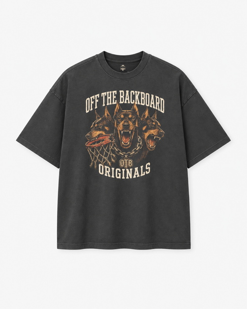 A dark gray graphic t-shirt featuring three roaring dogs and the text 'OFF THE BACKBOARD' and 'OTB ORIGINALS' in a distressed cream and orange print, shown against a light gray background.