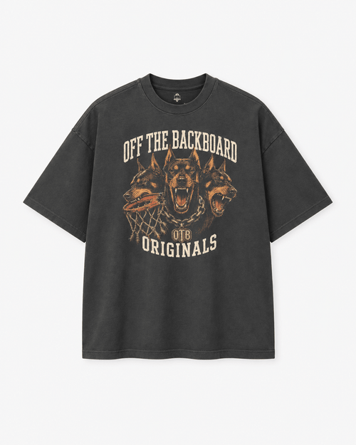 A dark gray graphic t-shirt featuring three roaring dogs and the text 'OFF THE BACKBOARD' and 'OTB ORIGINALS' in a distressed cream and orange print, shown against a light gray background.