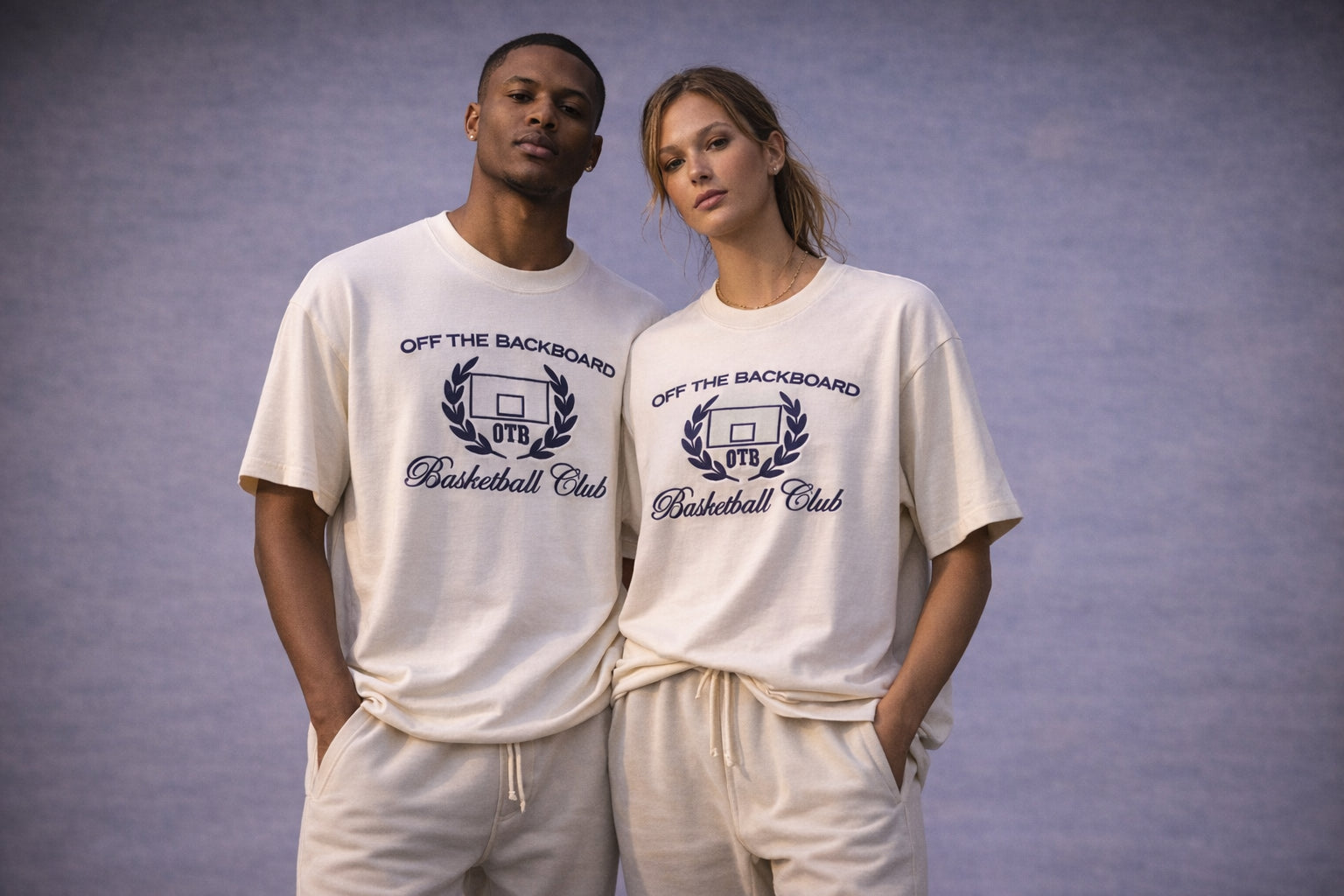 Two people wearing 'Off The Backboard Basketball Club' t-shirts against a gray background