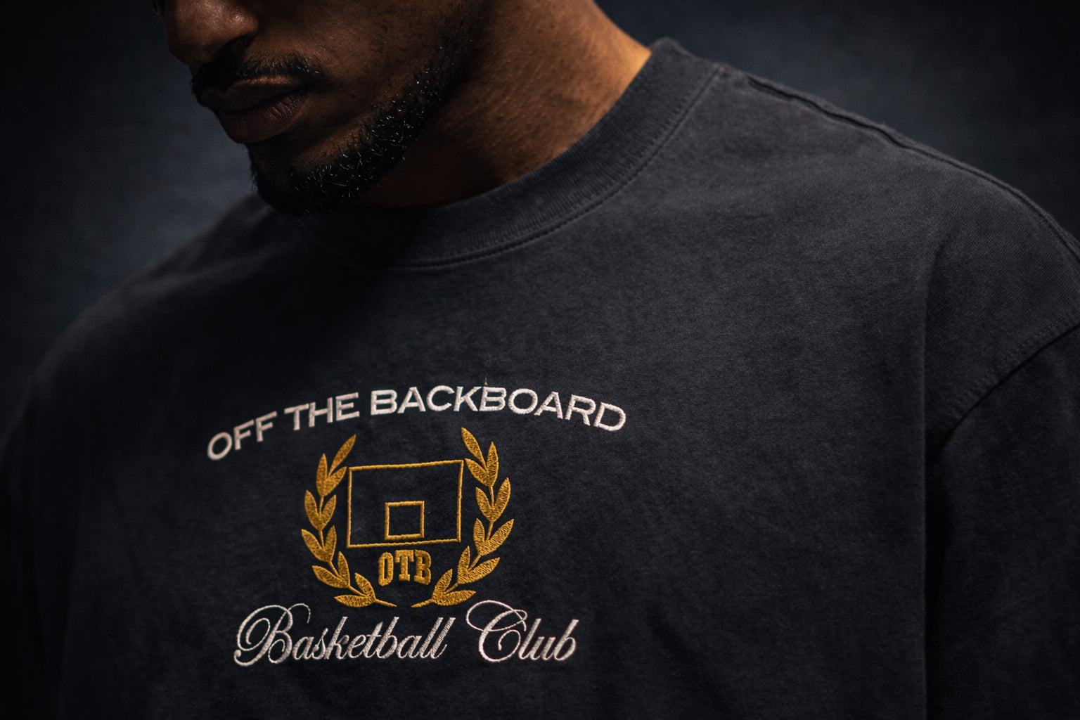 Black sweatshirt with 'Off The Backboard Basketball Club' logo on a dark background