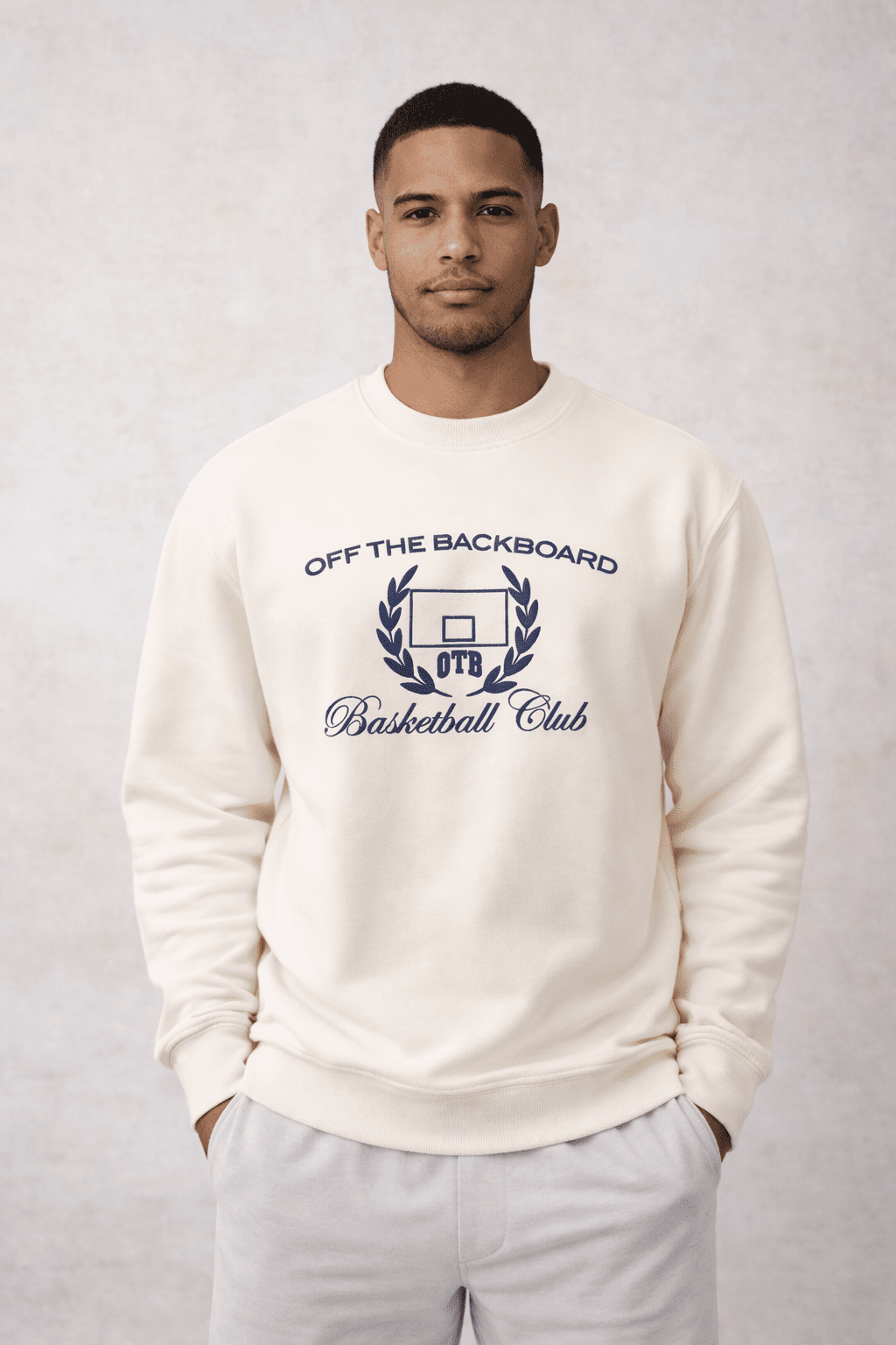 Man wearing a white sweatshirt with 'Off The Backboard Basketball Club' text and logo on a light gray background