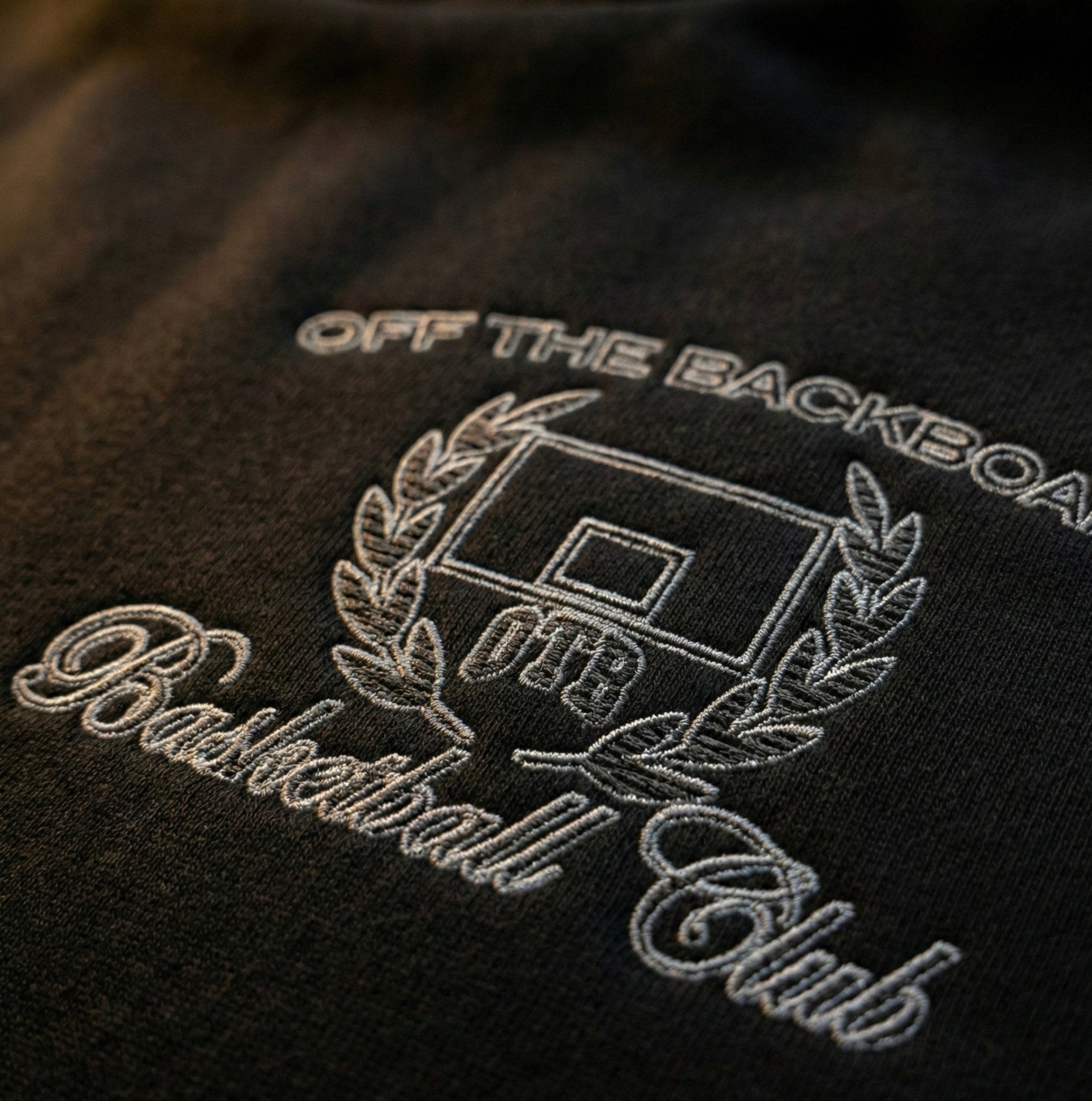 Embroidered logo on a black background with 'Off The Backboard Basketball Club' text.