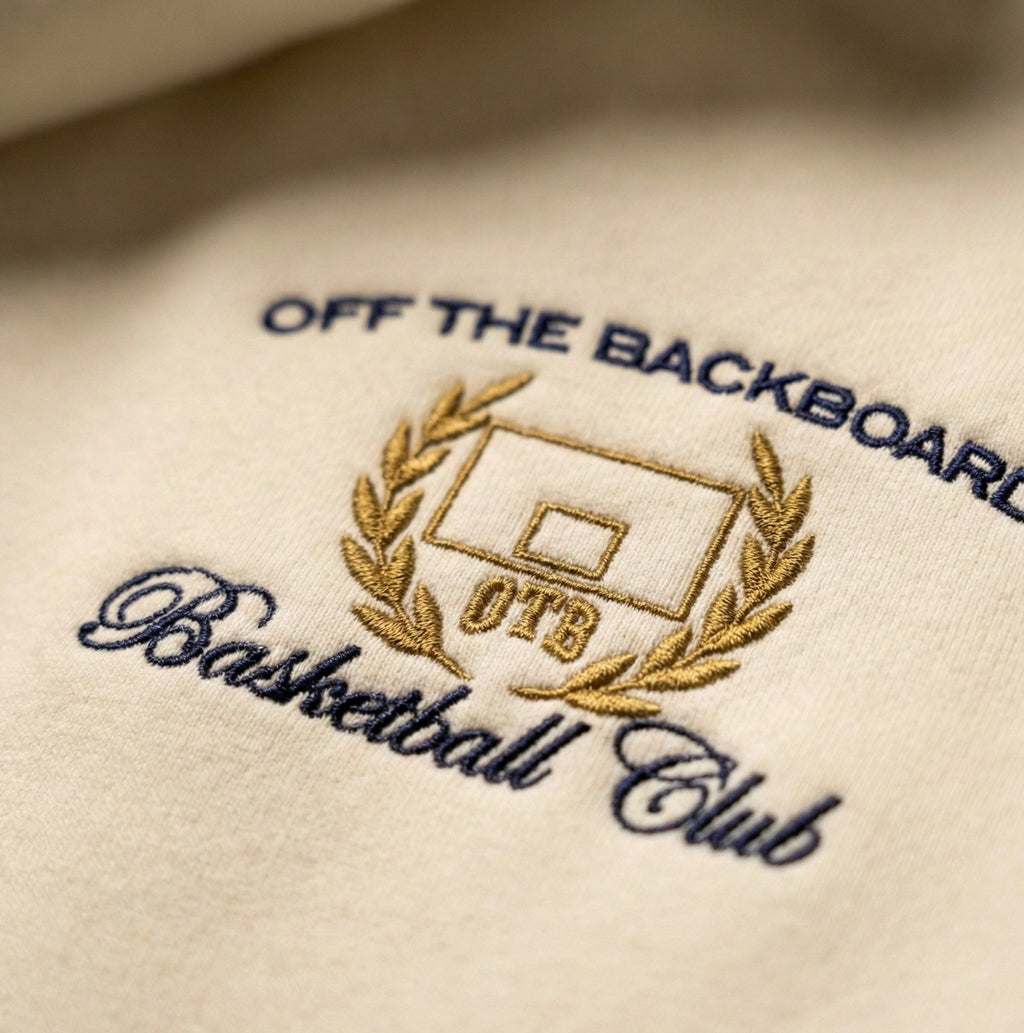 Embroidered logo on white fabric with 'Off The Backboard Basketball Club' text.