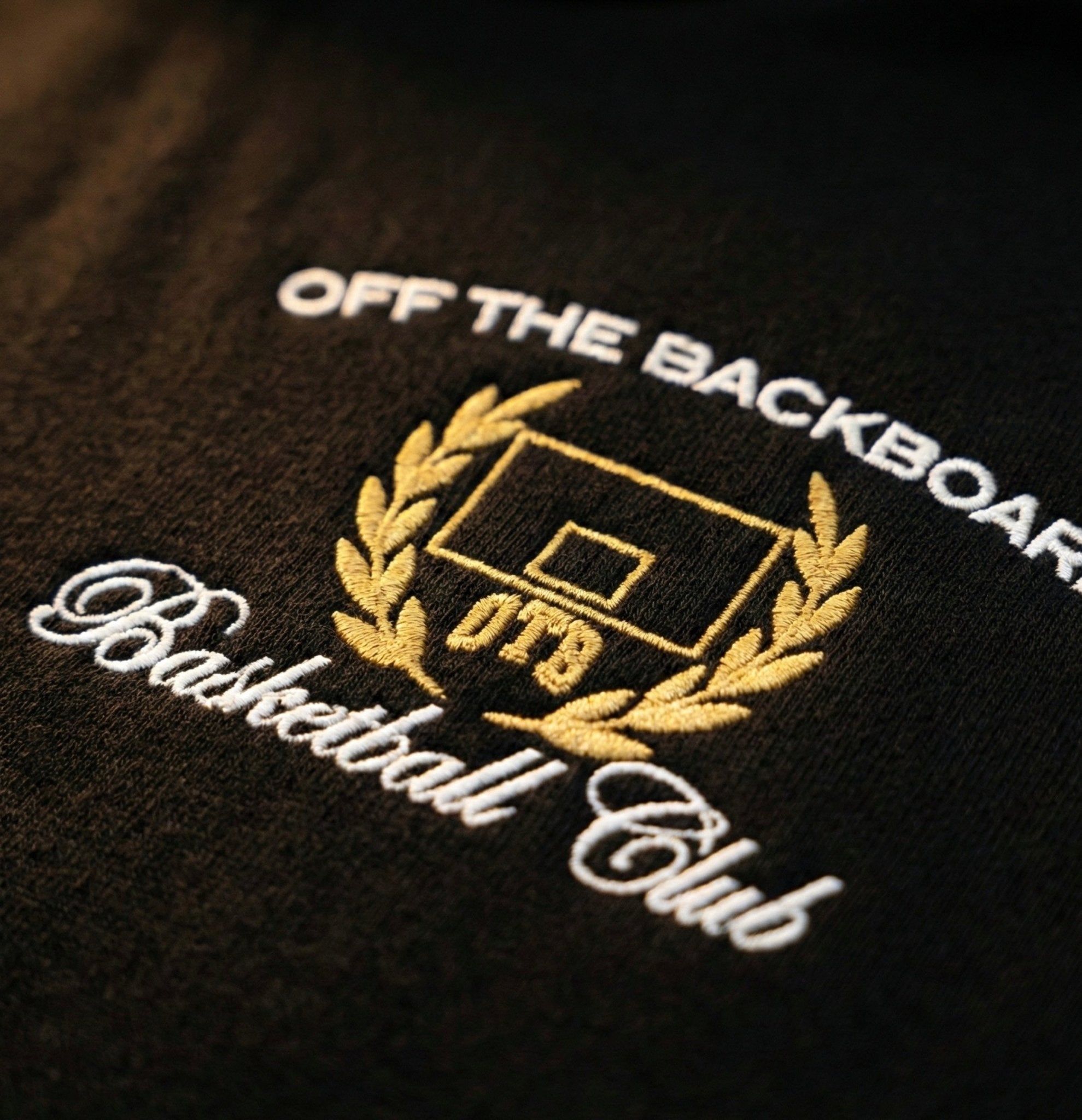 Embroidered logo on a black background with 'Off The Backboard Basketball Club' text.