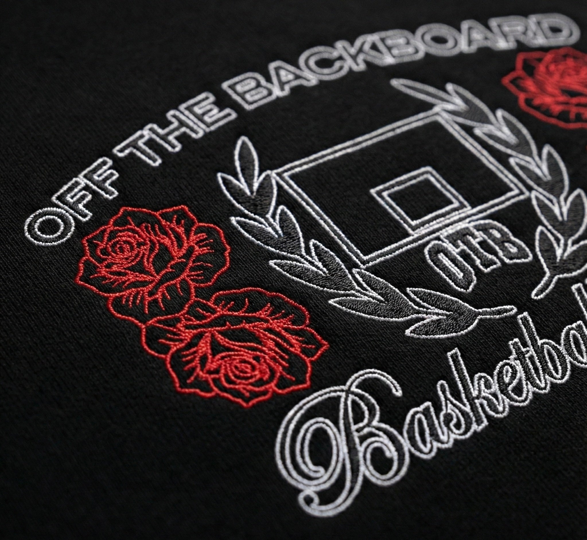 Embroidered design on a black fabric with roses and text, featuring 'Off the Backboard' branding.