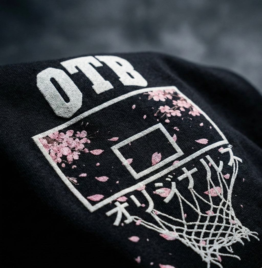 Black sweatshirt with 'OTB' and cherry blossom design on a dark background