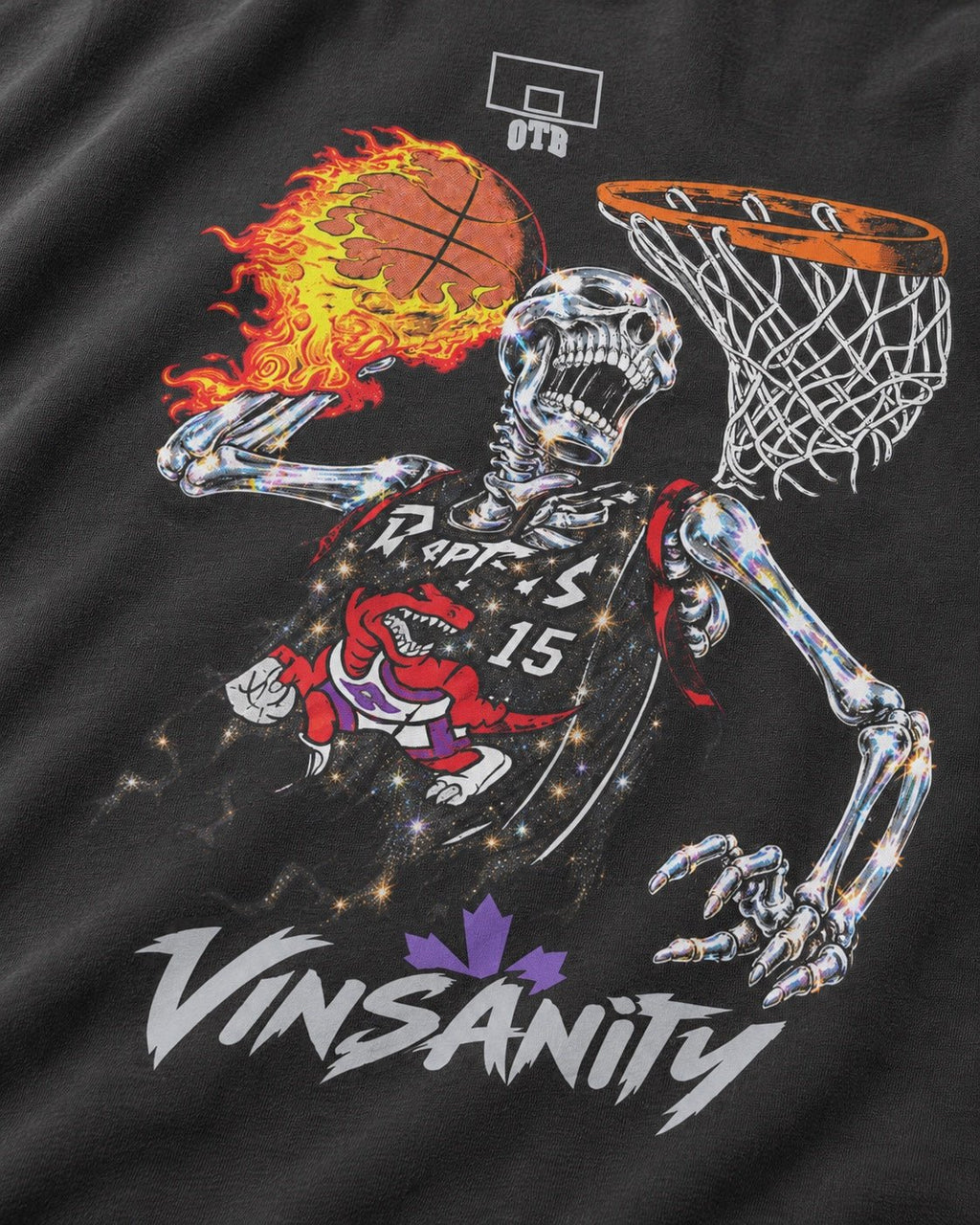 Close-up of a black graphic t-shirt featuring a skeleton basketball player in a Toronto Raptors jersey, holding a flaming basketball near a hoop, with the Vinsanity brand name and logo printed below.
